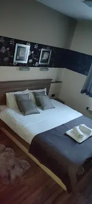 a bedroom with a large bed with three pictures on the wall at Apartman LuPa in Kopaonik