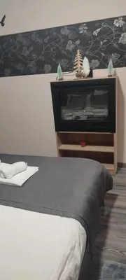 a bedroom with a bed and a dresser with a fireplace at Apartman LuPa in Kopaonik