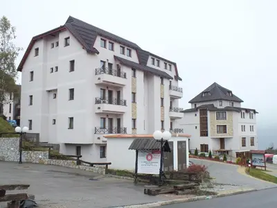a large white building with a sign in front of it at Apartman LuPa in Kopaonik