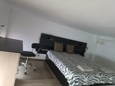 a bedroom with a bed and a desk and a chair at M Central Park in Niš