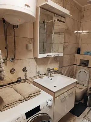 a bathroom with a sink and a washing machine at M Central Park in Niš