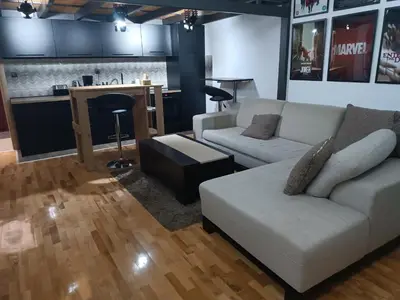 a living room with a white couch and a kitchen at M Central Park in Niš