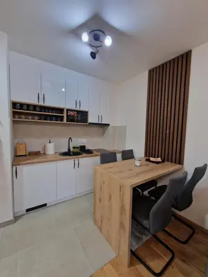 a kitchen with a wooden table and chairs at My happy place Vrnjačka Banja in Vrnjačka Banja