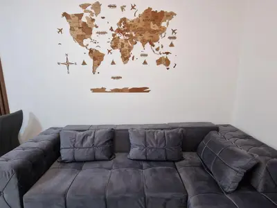 a leather couch in a living room with a world map on the wall at My happy place Vrnjačka Banja in Vrnjačka Banja