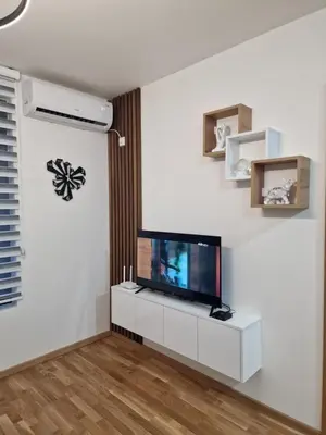 a living room with a flat screen tv on a white wall at My happy place Vrnjačka Banja in Vrnjačka Banja