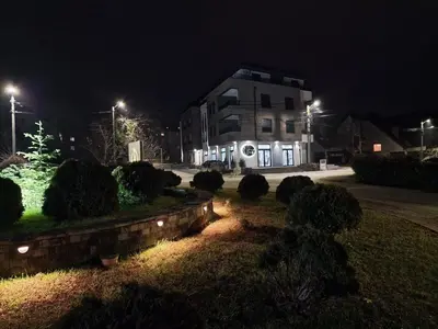 a building at night with bushes and lights in front at My happy place Vrnjačka Banja in Vrnjačka Banja