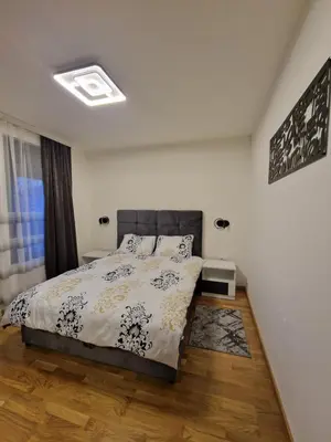 a bedroom with a bed with a black and white comforter at My happy place Vrnjačka Banja in Vrnjačka Banja