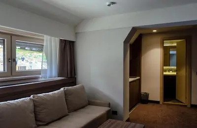 a living room with a couch and a window at Apartman Spust Angella in Kopaonik