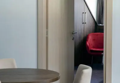 a room with a table and a red chair at Apartman Spust Angella in Kopaonik