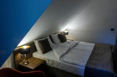 a bedroom with a bed with a blue wall at Apartman Spust Angella in Kopaonik
