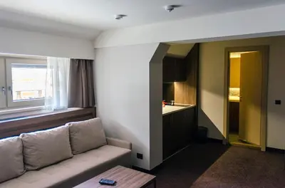 a living room with a couch and a kitchen at Apartman Spust Angella in Kopaonik