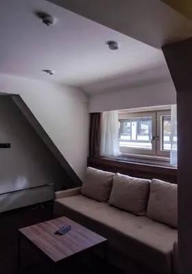 a living room with a couch and a window at Apartman Spust Angella in Kopaonik