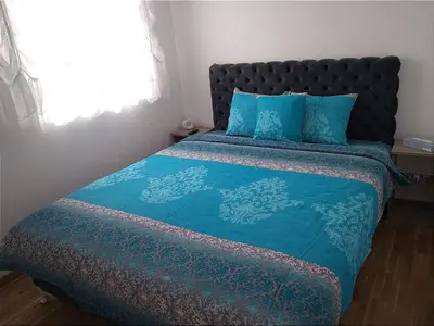 a bedroom with a bed with blue sheets and a window at Marta i Marija 2 in Vrnjačka Banja