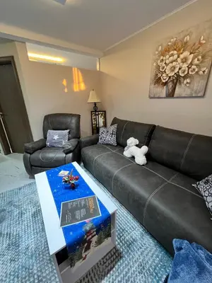 a living room with a leather couch and a table at Apartman Zimska idila in Kopaonik