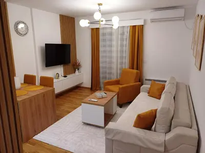a living room with a couch and a tv at Larso Lux, free swimming pools & parking in Vrnjačka Banja