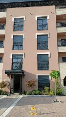 a building with windows and a yellow sign in front of it at Larso Lux, free swimming pools & parking in Vrnjačka Banja