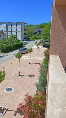 a group of trees on a sidewalk next to a building at Larso Lux, free swimming pools & parking in Vrnjačka Banja