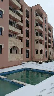 an empty swimming pool in front of an apartment building at Larso Lux, free swimming pools & parking in Vrnjačka Banja