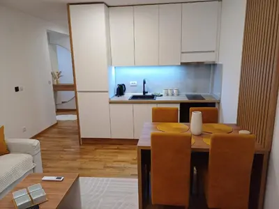a kitchen and dining room with a table and chairs at Larso Lux, free swimming pools & parking in Vrnjačka Banja