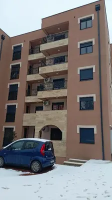 a blue car parked in front of a building at Larso Lux, free swimming pools & parking in Vrnjačka Banja