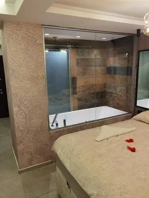a bathroom with a tub and a bed with red roses on it at Pavlovic Luxury Spa in Vrnjačka Banja