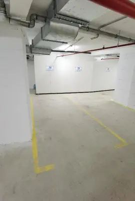 an empty parking garage with white walls and yellow lines at Pavlovic Luxury Spa in Vrnjačka Banja