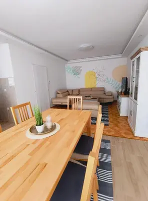 a living room with a wooden table and a couch at Apartman Mina in Pirot