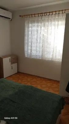 a bedroom with a bed and a large window at Apartman Mina in Pirot