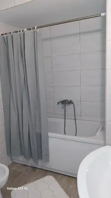 a bathroom with a bath tub with a shower curtain at Apartman Mina in Pirot