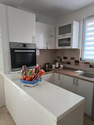 a kitchen with a bowl of fruits and vegetables on a counter at Apartman Mina in Pirot
