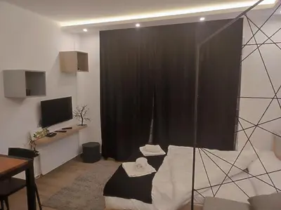 a living room with a black curtain and a desk at Epic Apartments in Kopaonik