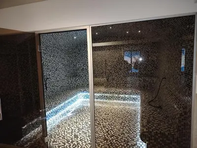 a bathroom with a glass door with a swimming pool at Epic Apartments in Kopaonik