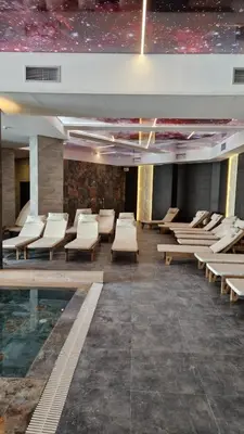 a room with chairs and a pool in a building at Epic Apartments in Kopaonik