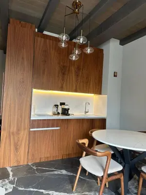 a kitchen with wooden cabinets and a table with chairs at Apartman Stotka in Kopaonik