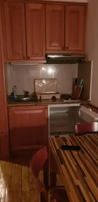 a kitchen with wooden cabinets and a stove top oven at Apartman Sivi Vuk Kopaonik in Kopaonik