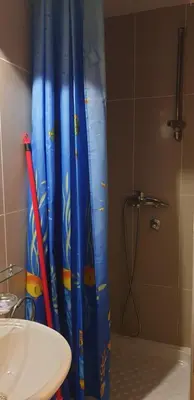 a shower curtain in a bathroom with a sink at Apartman Sivi Vuk Kopaonik in Kopaonik