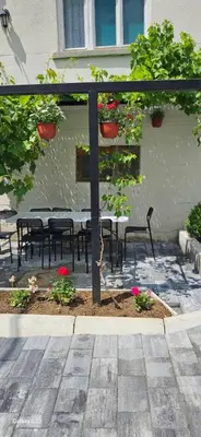a patio with a table and chairs with potted plants at Temački amanet in Pirot