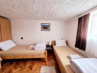 two beds in a small room with a window at Temački amanet in Pirot