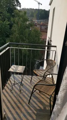two chairs and a table on a balcony at LILLY apartman in Vrnjačka Banja