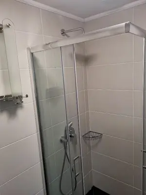 a shower with a glass door in a bathroom at LILLY apartman in Vrnjačka Banja