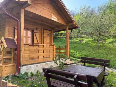 a wooden cabin with a bench and a table at Brvnara Novičić in Vrnjačka Banja