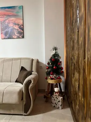 a christmas tree in a living room with a couch at Apartman Vučko in Kopaonik