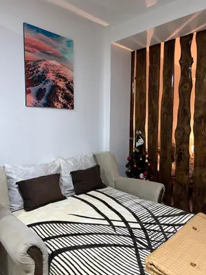 a bedroom with a bed and a christmas tree at Apartman Vučko in Kopaonik