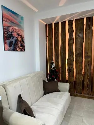 a living room with a white couch and a christmas tree at Apartman Vučko in Kopaonik