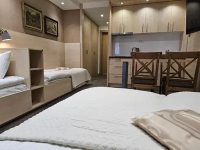 a hotel room with two beds and a kitchen at Konak Zvečan 307 in Kopaonik