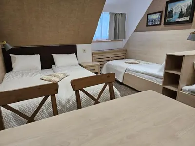 a small room with two beds and a table at Konak Zvečan 307 in Kopaonik