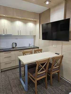 a kitchen with a table and chairs and a television at Konak Zvečan 307 in Kopaonik