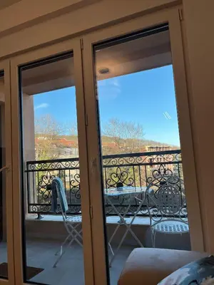 a glass door with a view of a balcony at Eden Apartman Vrnjačka Banja in Vrnjačka Banja