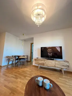 a living room with a tv and a table at Eden Apartman Vrnjačka Banja in Vrnjačka Banja