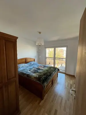 a bedroom with a bed and a large window at Eden Apartman Vrnjačka Banja in Vrnjačka Banja